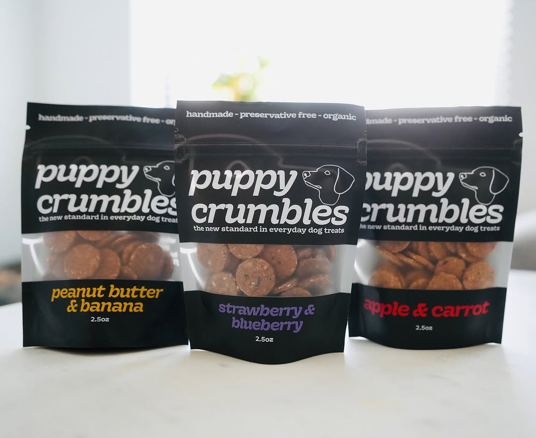 Three packages of Puppy Crumbles dog treats on a white background
