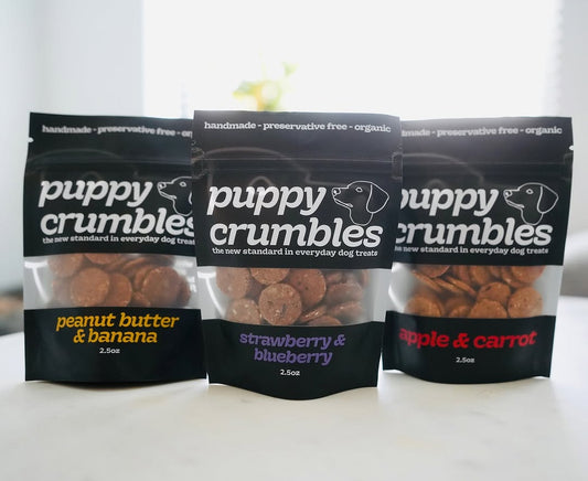 Three packages of Puppy Crumbles dog treats on a white background